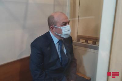Eldar Həsənov şüşə qəfəsdən çıxarılaraq məhkəmə zalında oturub